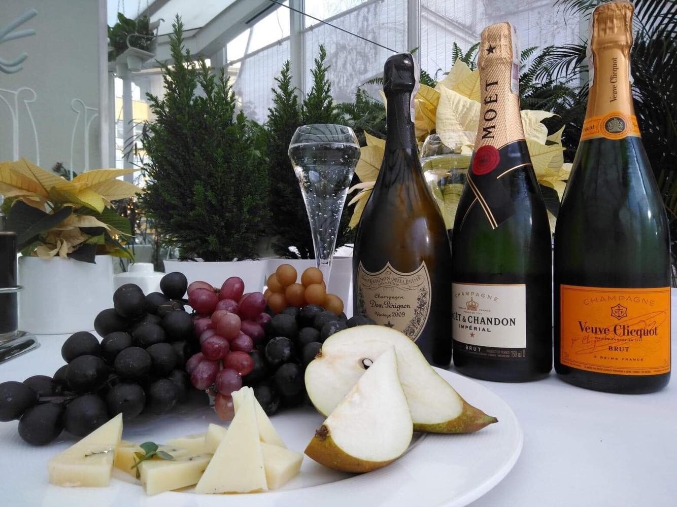 Artyku_na_bloga_-_szampany_Nowy_Swiat Butelki wina i sery z owocami podane do stołu w restauracji